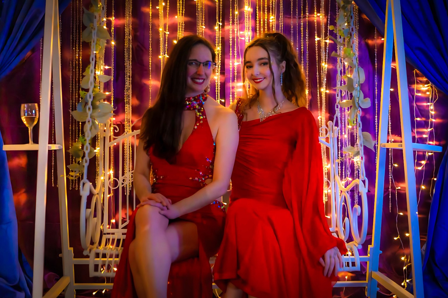 Two guests in red dresses posing at an event photographed by Kota's Visual Vibes